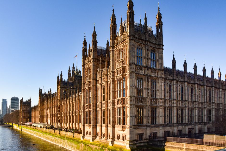 The Palace of Westminster in Westminster, London, with its Gothic Revival architecture featuring ornate towers and spires. The building's stone facade appears clean and well-maintained, with large win